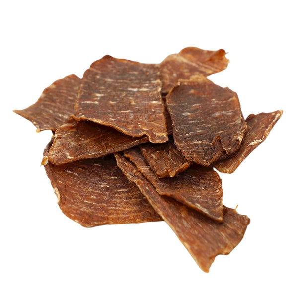 Dried beef jerky pieces on a white background